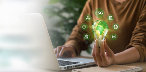 ESG environment social governance investment business concept.  woman's hand holding a light bulb surrounded by ESG icons. Sustainable Resources. Environmental and Business Growth Together.Copy space.