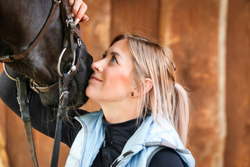 Young woman in head portraits, she looks dreamily at her horse..
