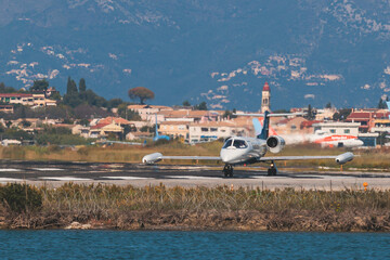 Fototapeta na wymiar View of modern private reactive aircraft on an runway airfield ready to take off, airstrip with business jet airplane before the flight with mountains in the background in a summer sunny day