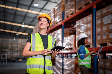 Industry warehouse worker in helmets with order details and checking goods  supplies on boxes shelve in workplace warehouse industry logistic export import distribution business concept