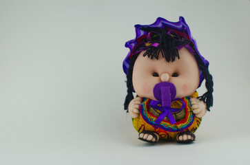 Peruvian doll in white background. Baby girl with a pacifier wearing a typical Peruvian dress.
