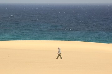 People playing in the Sahara Desert. Jumps and walks on the dunes of the Corralejo natural park.