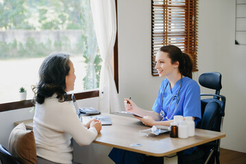 Obraz premium Asian Doctor and patient discussing something while sitting at the table . Medicine and health care concept. .