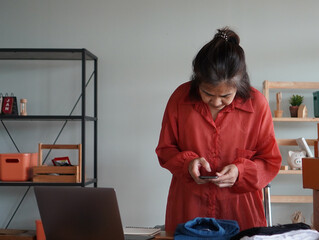 person working on computer, woman use mobile take photo T-Shirt for sell online 