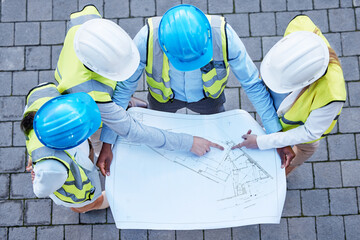Blueprint, pointing and engineering with people on construction site from top view for planning,...