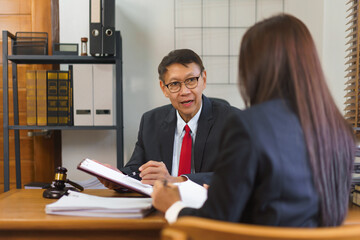 Legal and justice concept, Senior lawyer pointing on contract and discussing with female lawyer