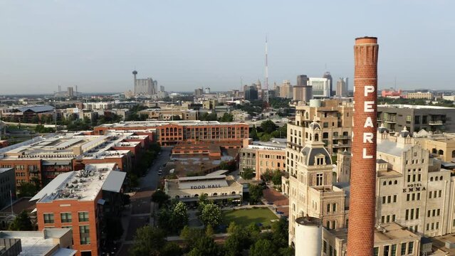 San Antonio Pearl District aerial view pan left past brick tower, shops and restaurants with drone in 4k