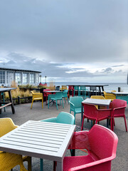 Multi-colored chairs on the terrace of a cafe by the sea.