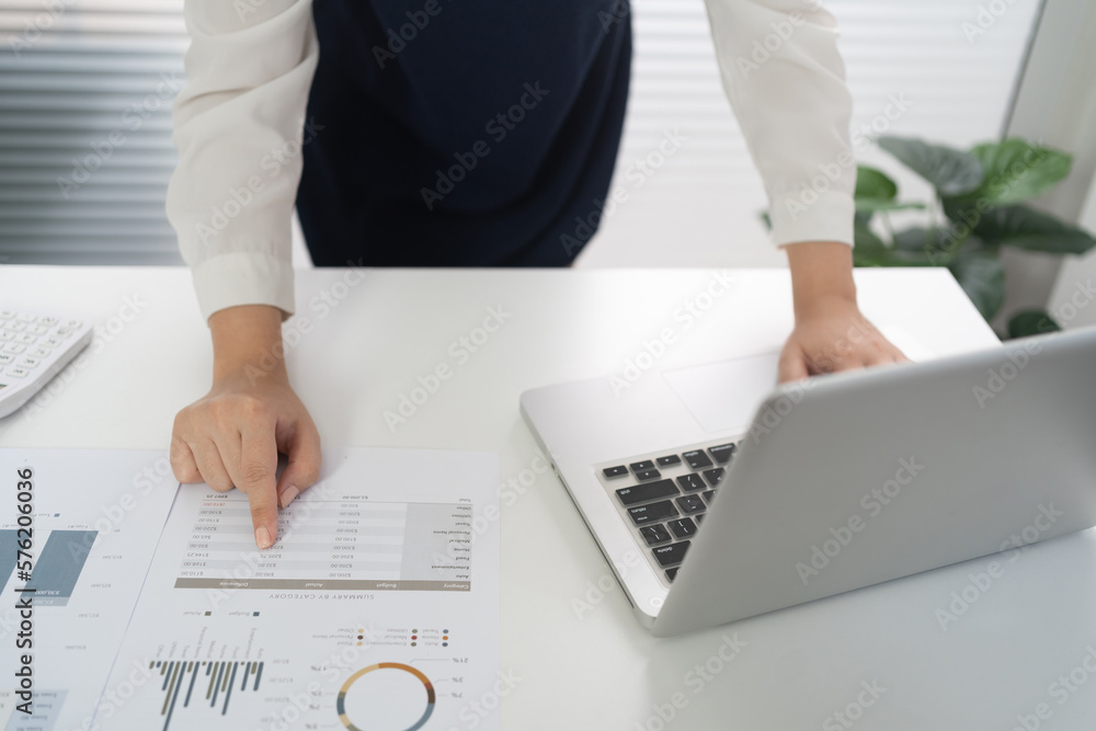 Wall mural businesswoman accountant analyzing investment charts invoice and pressing calculator buttons over do