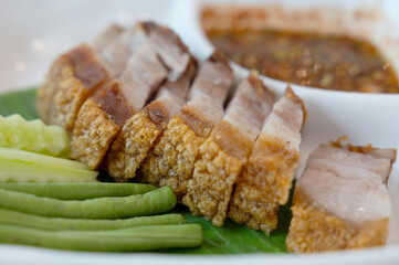 Deep-fried pork belly on a plate with fresh greens