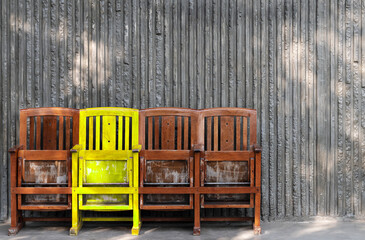 Different yellow wooden chair. Think differently concept