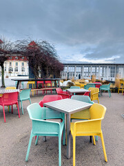 Multi-colored chairs on the terrace of a cafe by the sea.