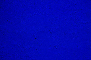 Old textured blue paint on a concrete wall.