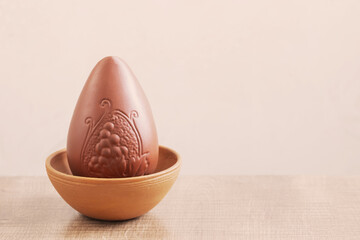 chocolate easter egg on plate on white background