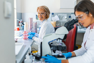 Scientist in lab doing research and using lab machines, test tubes, microscope and every laboratory equipment