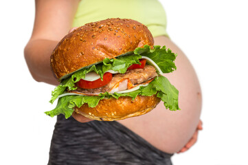 Pregnant woman with belly is holding a burger