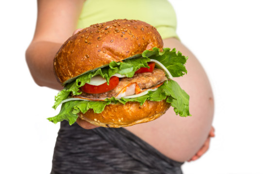 Pregnant woman with belly is holding a burger