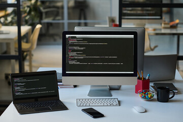 Horizontal image of workplace of developer with computers in IT office