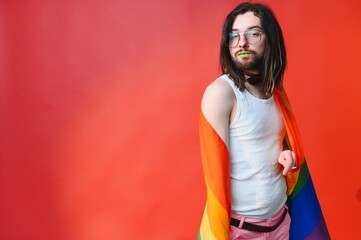 Young, handsome gay man on a colored background in the studio. LGBT concept.