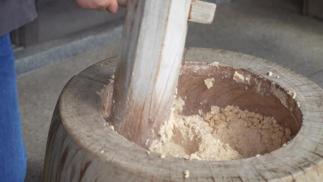 杵と臼で大豆をつぶす様子　味噌作り体験イメージ