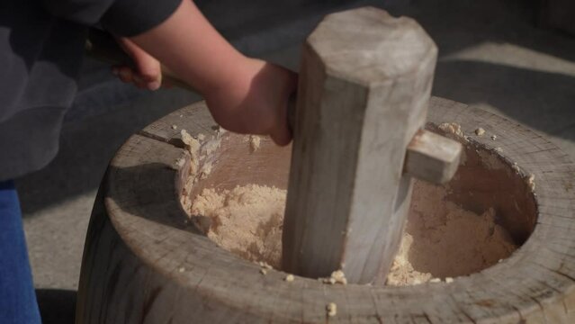 杵と臼で大豆をつぶす様子　味噌作り体験イメージ