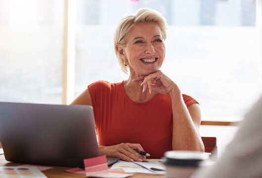 Laptop, thinking and management with a senior woman in business, sitting at a table in the boardroom. Computer, thinking and smile with a happy female in leadership working alone in her office