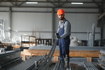 Fototapeta premium Portrait of Professional Heavy Industry Engineer Worker Wearing Safety Uniform, Hard Hat Smiling. In the Background Unfocused Large Industrial Factory.