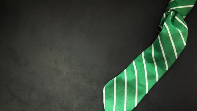 Elegant green business tie on dark background Elegant man clothes concept. wardobe and accessories for official party or evening meeting. Placed on black backgound. tie. Top view. Flat lay with copy