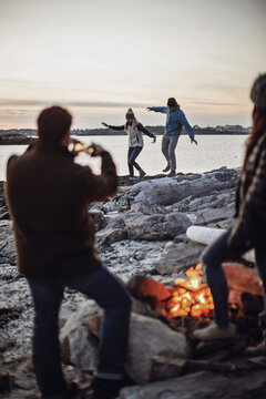 Group of&Acirc;&nbsp;friends&Acirc;&nbsp;around&Acirc;&nbsp;beachside&Acirc;&nbsp;campfire, Peaks Island, Maine, USA