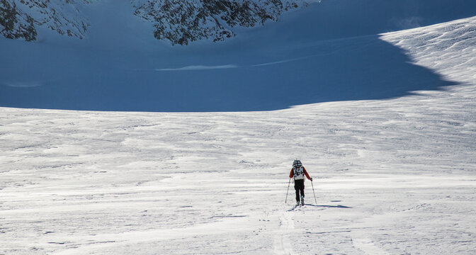 A skier skins across a wide open expanse of snow during the Spearhead Traverse in the Coast Mountains of British Columbia, Canada.