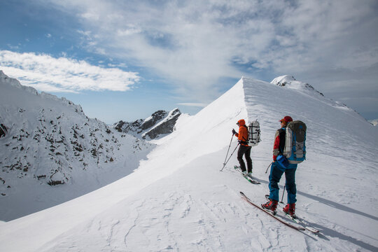 Skiers along a steep ridge during the Spearhead Traverse in the Coast Mountains of British Columbia, Canada.
