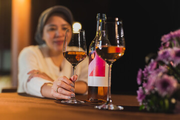 Woman hand holding wine glass on dinner table in the restaurant.