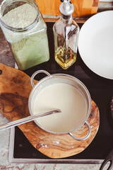 Making thin pancakes on frying pan in kitchen, with cooking dough for crepes and pancakes