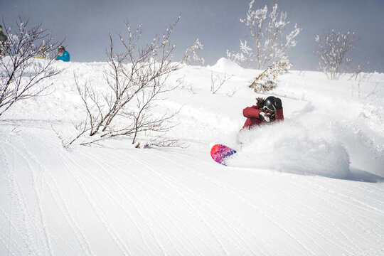 A Snowboarder Sandra Hillen Riding Through Powder In The Japanese Alps