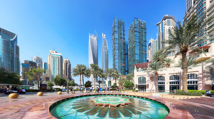 Fototapeta na wymiar Dubai, UAE, January 11 2023: Fountain in Dubai Marina canal and promenade in beautiful summer day,Dubai,United Arab Emirates