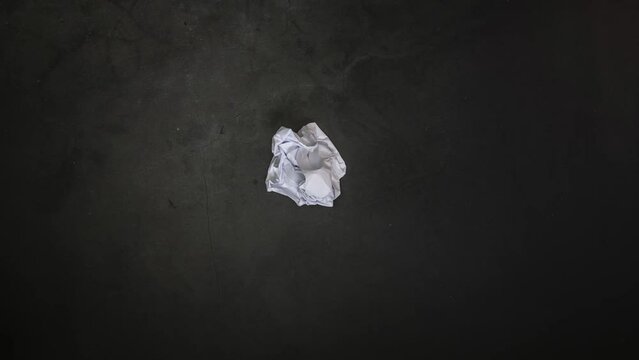 4K Crumpled Paper close-up animation on black background. folding open and closed top view modern design concrete background