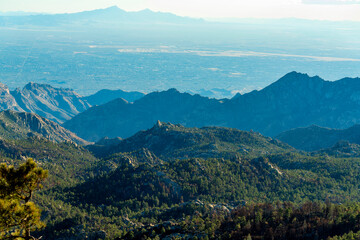 Rolling ridge hills in the cliffs of arizona wilderness in dry season desert with mountain and hazy blue sun skies