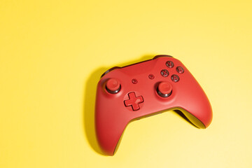 red game controller isolated on yellow background © TropicalNinjaStudio
