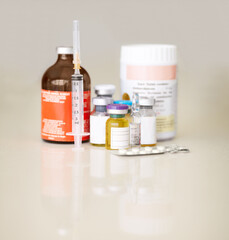 A mass of medicine. Bottles of medicine and pills with a syringe and needle.