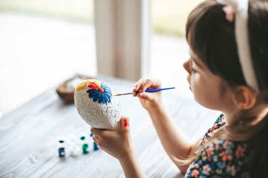 Little girl painting Easter egg