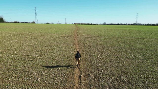 Drone following man walking through a field on a path in Great Missenden