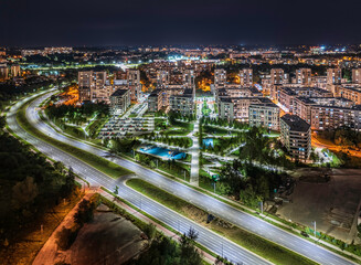Long exposure of blocks of flats at night with traffic trails and lights - modern Krakow cityscape