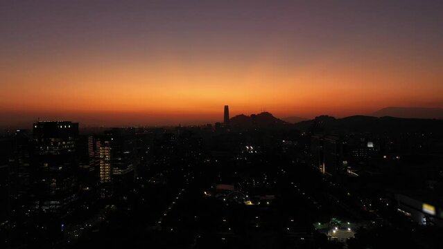 Sparkling Santiago City Silhouette at Sunset. Aerial View. Evening Twilight. Blue Hour. Las Condes Commune. Chile. Drone Flies Forward and Upwards