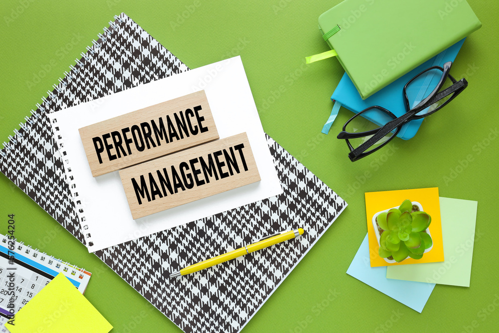 Poster performance management. green background. text on paper. green and blue notepad.