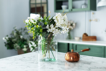 Summer white flowers and turk with coffee in kitchen table. Bouquet of flowers and plants in glass...