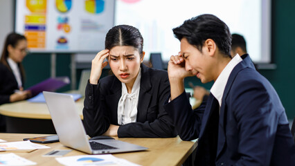 Millennial Asian stressed depressed worried thoughtful professional male businessman female businesswoman employee staff in formal business suit sitting thinking solving problem ideas in office room