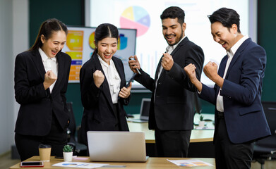 Millennial Asian Indian professional male businessmen female businesswomen employee staff colleagues in formal business suit standing discussing brainstorming working together with laptop computer