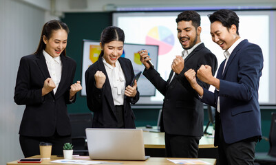 Millennial Asian Indian professional male businessmen female businesswomen employee staff colleagues in formal business suit standing discussing brainstorming working together with laptop computer