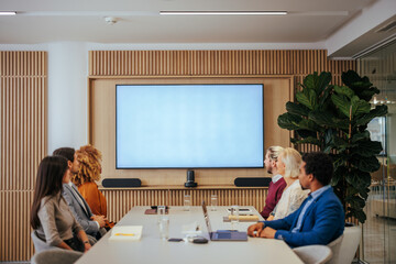 Businesspeople watching screen in meeting room.