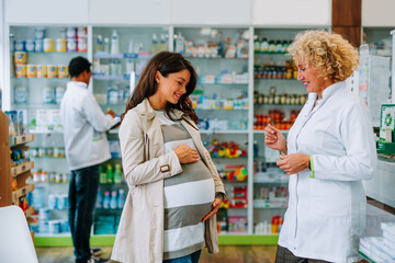 Fototapeta na wymiar Happy pregnant woman in drugstore.